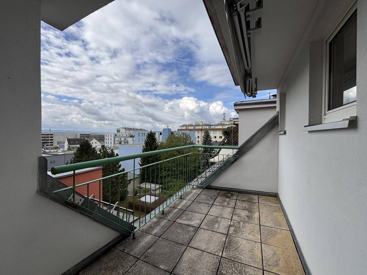 Geräumiger Balkon mit Fliesenboden und weitem Blick über die Stadt.