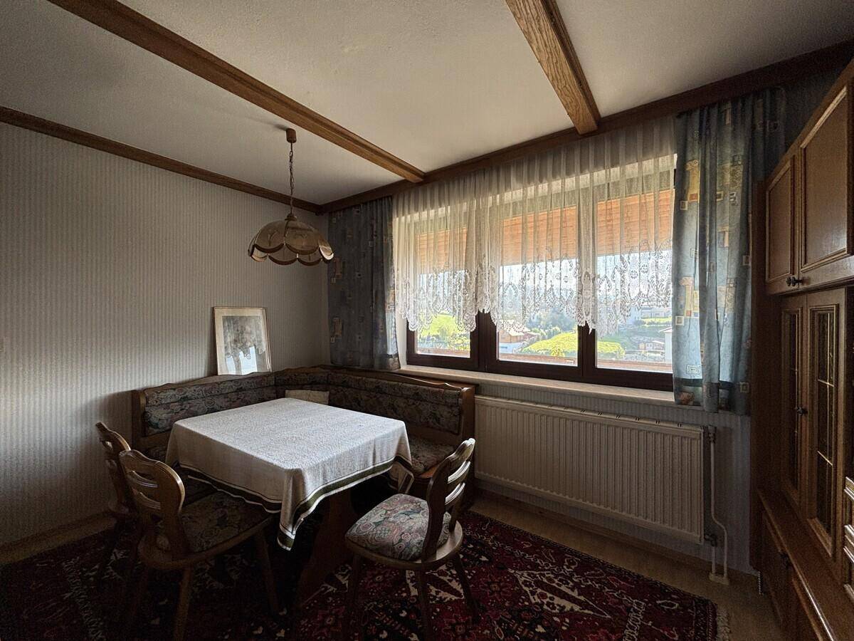 Gemütlicher Essbereich mit Holzbalkendecke, Eckbank und traditionellen Möbeln.