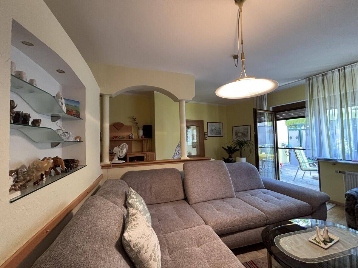 Gemütliches Wohnzimmer mit Ecksofa, Couchtisch und Blick auf die Terrasse.