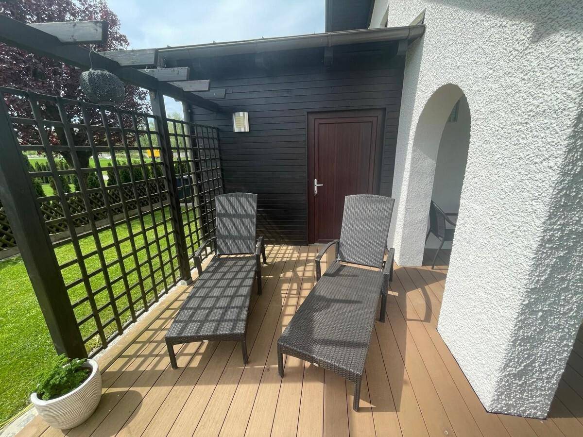 Gemütlicher Bereich der Terrasse mit Sonnenliegen und Sichtschutz für entspannte Stunden.
