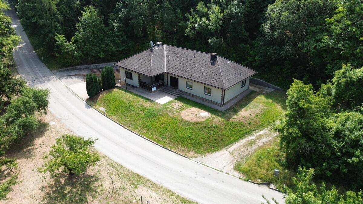 Weitläufige Luftaufnahme des Hauses in ländlicher Umgebung mit Zufahrtsstraße und viel Grün.