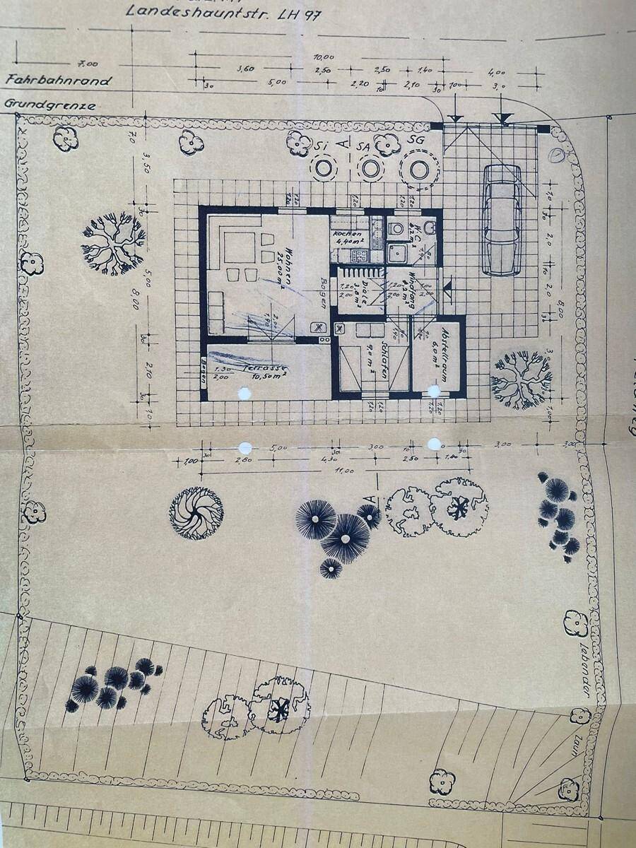 Detaillierter Grundriss des Hauses mit Gartenanlage und Parkplatz.