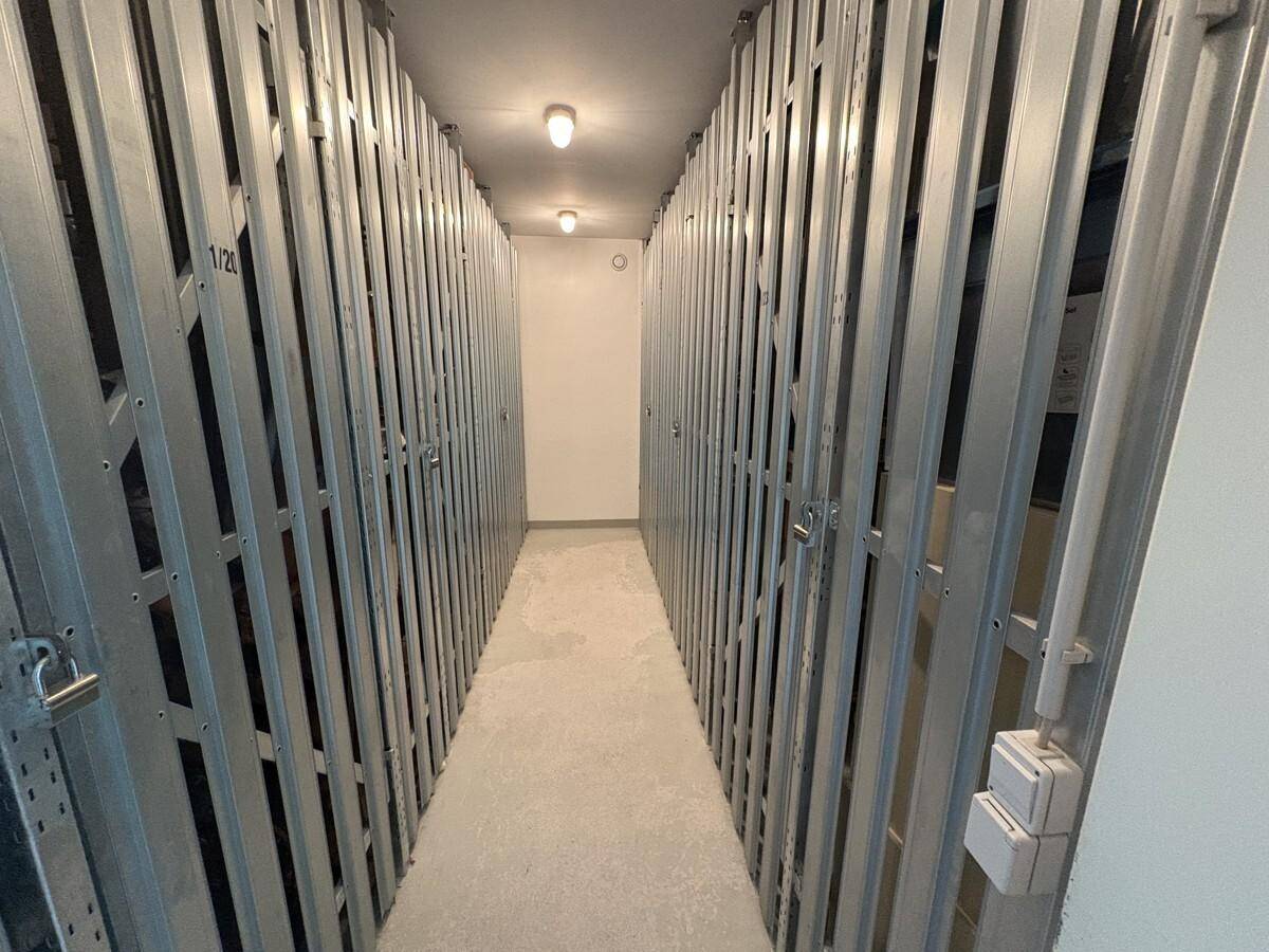Langer Lagerraum im Keller mit Metallabtrennungen, bietet individuelle Abstellmöglichkeiten.