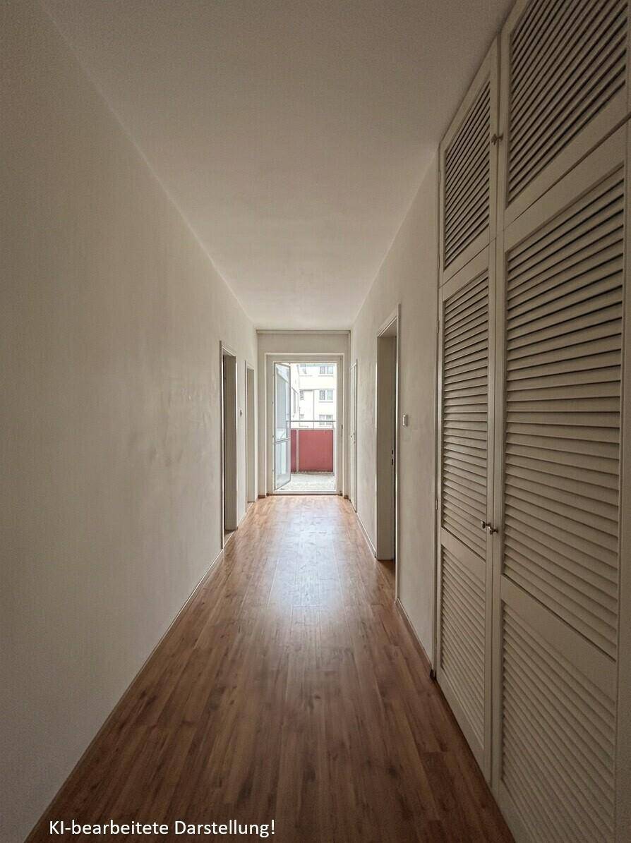 Langer Flur mit Holzfußboden und integrierten Schränken, der zu einem weiteren Balkon führt.
