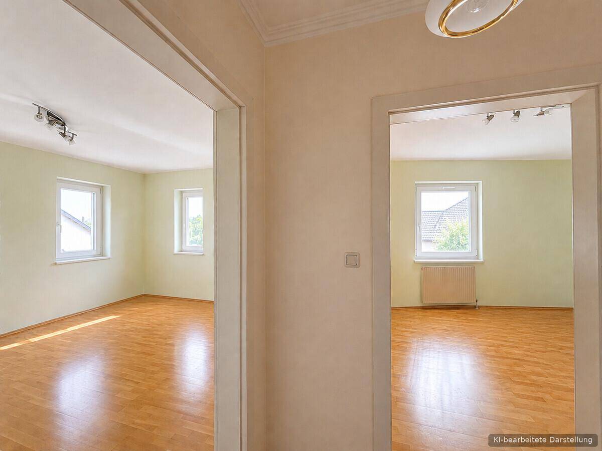 Blick vom Flur in zwei helle Zimmer mit Parkettboden und freundlichen grünen Wänden.