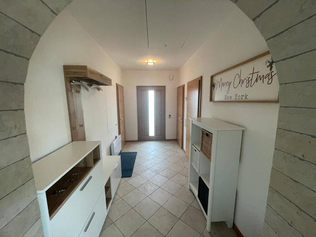 Einladender Eingangsbereich mit Fliesenboden, Garderobe und Blick zur Haustür.