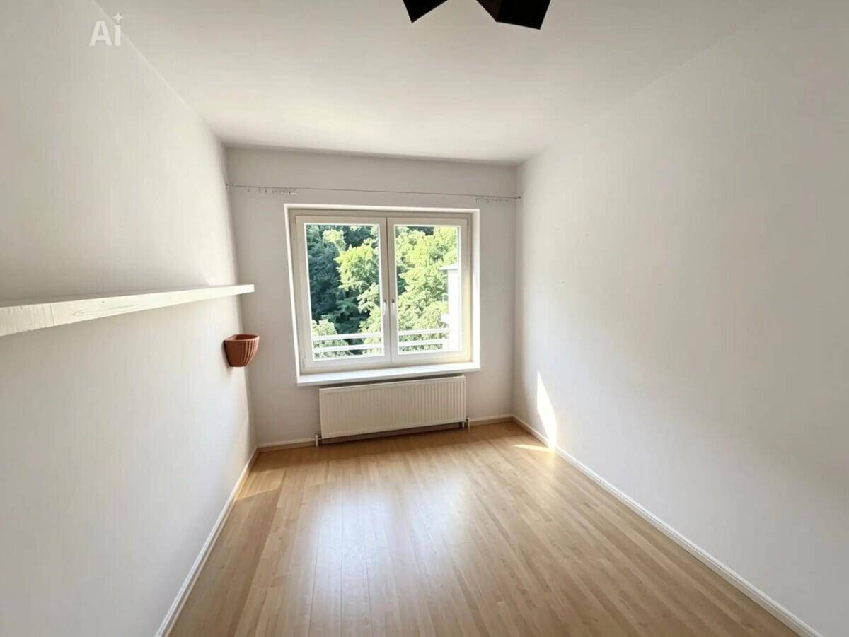 Helles Schlafzimmer mit Laminatboden und Fenster, das einen grünen Ausblick bietet.