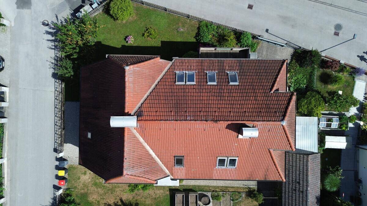 Dachansicht des Hauses mit roten Ziegeln und mehreren Dachfenstern.