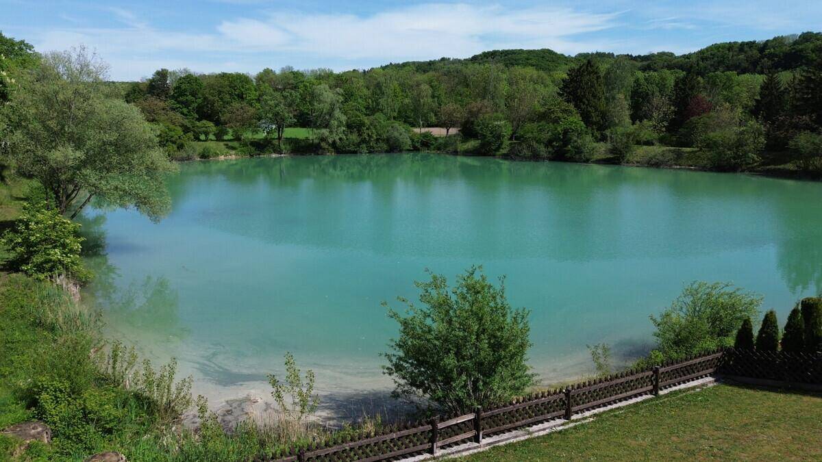 Malerischer Blick auf den türkisfarbenen See, umgeben von üppiger grüner Natur.