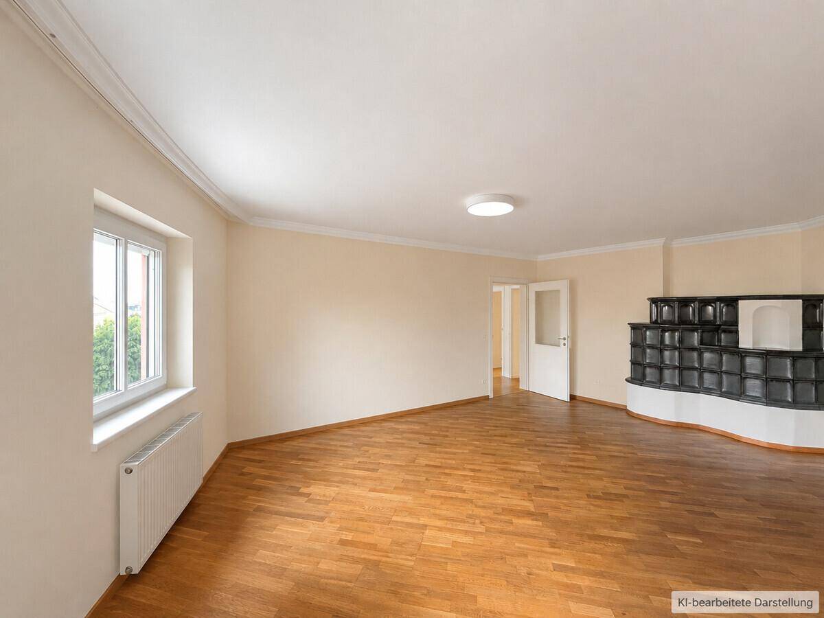 Gemütliches Zimmer mit Parkettboden, hellen Wänden und einem traditionellen Kachelofen in der Ecke.