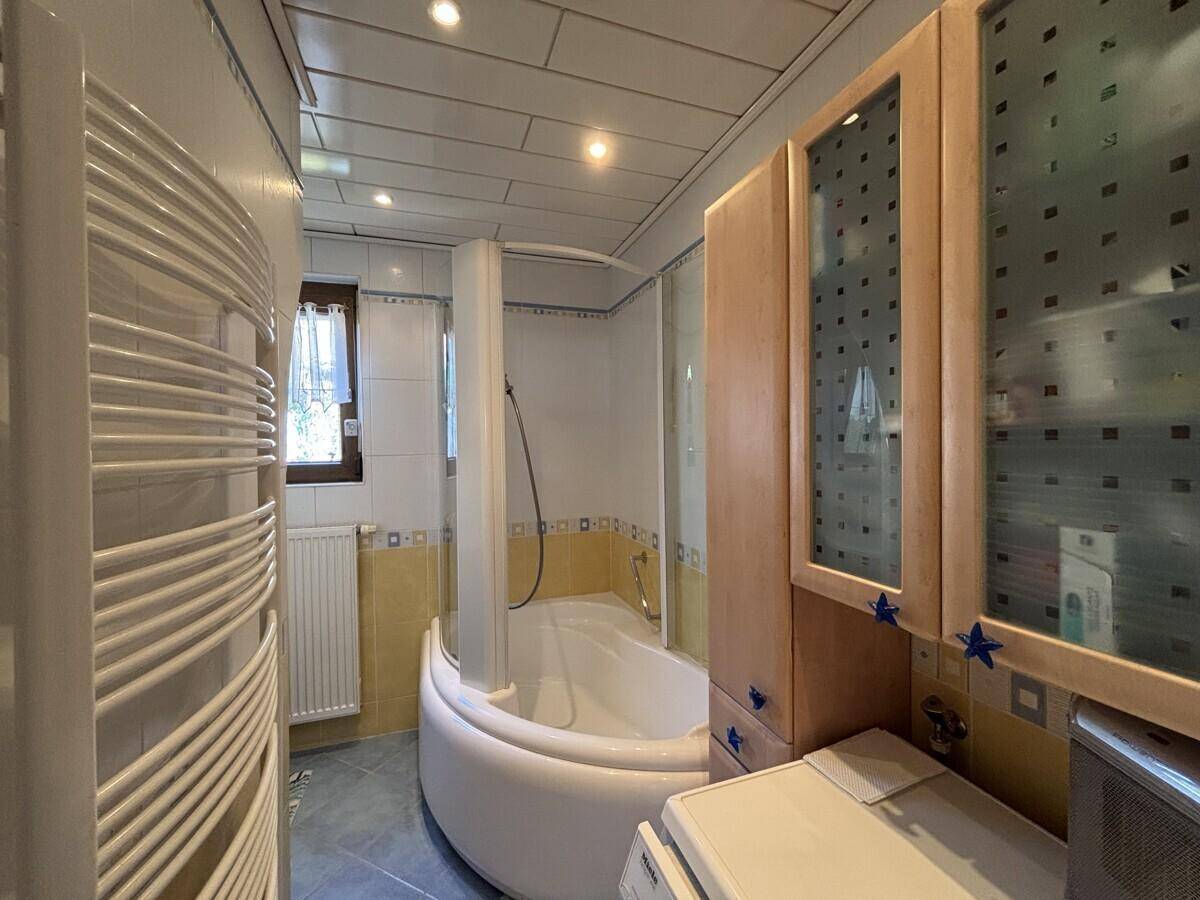Badezimmer mit Eckbadewanne, Duschkabine und beheiztem Handtuchhalter.