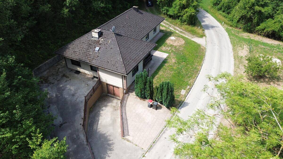 Rückansicht des Hauses von oben mit gepflastertem Hofbereich und Garagenzufahrt.