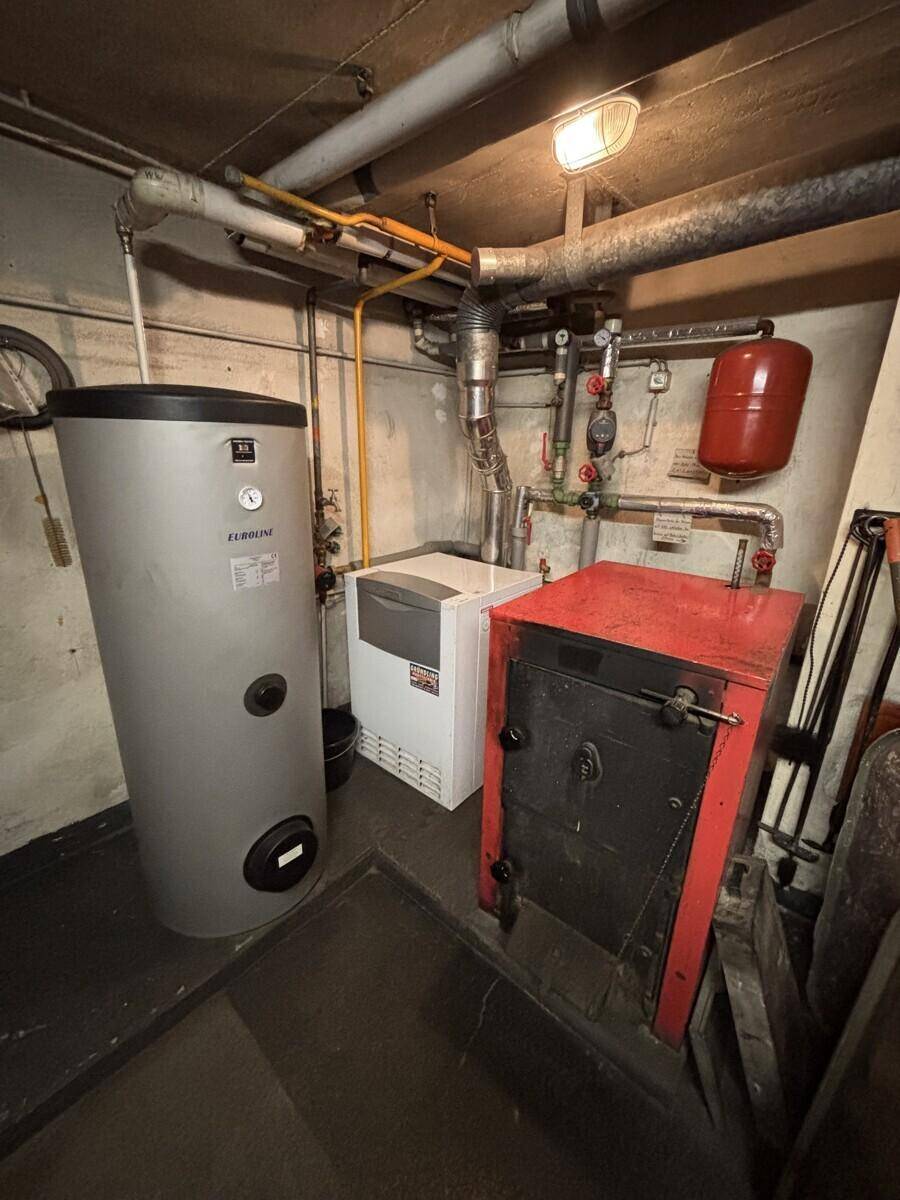 Heizungsraum im Keller mit Warmwasserspeicher und Heizkessel.