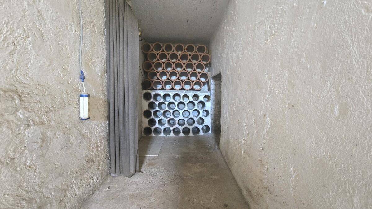Kellerraum mit Tonröhren zur Lagerung von Flaschen und rauen Wänden, ideal als Weinkeller.