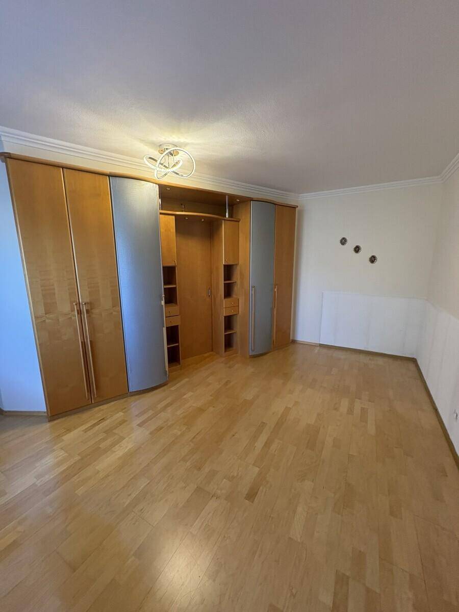 Geräumiges Schlafzimmer mit großem Einbauschrank und hellem Holzboden.