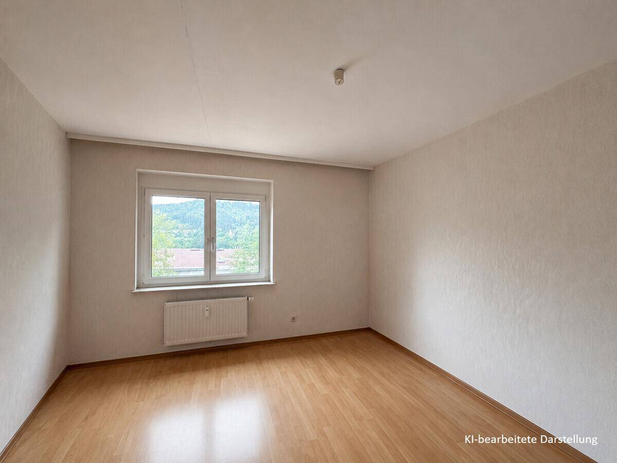 Helles Schlafzimmer mit Parkettboden und Fenster, das einen weiten Blick in die Landschaft bietet.