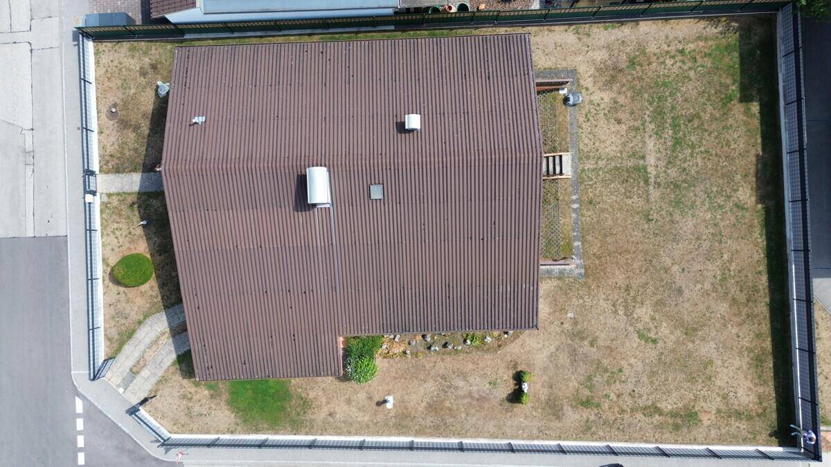 Draufsicht des Hauses mit braunem Satteldach und der Grundstücksaufteilung.