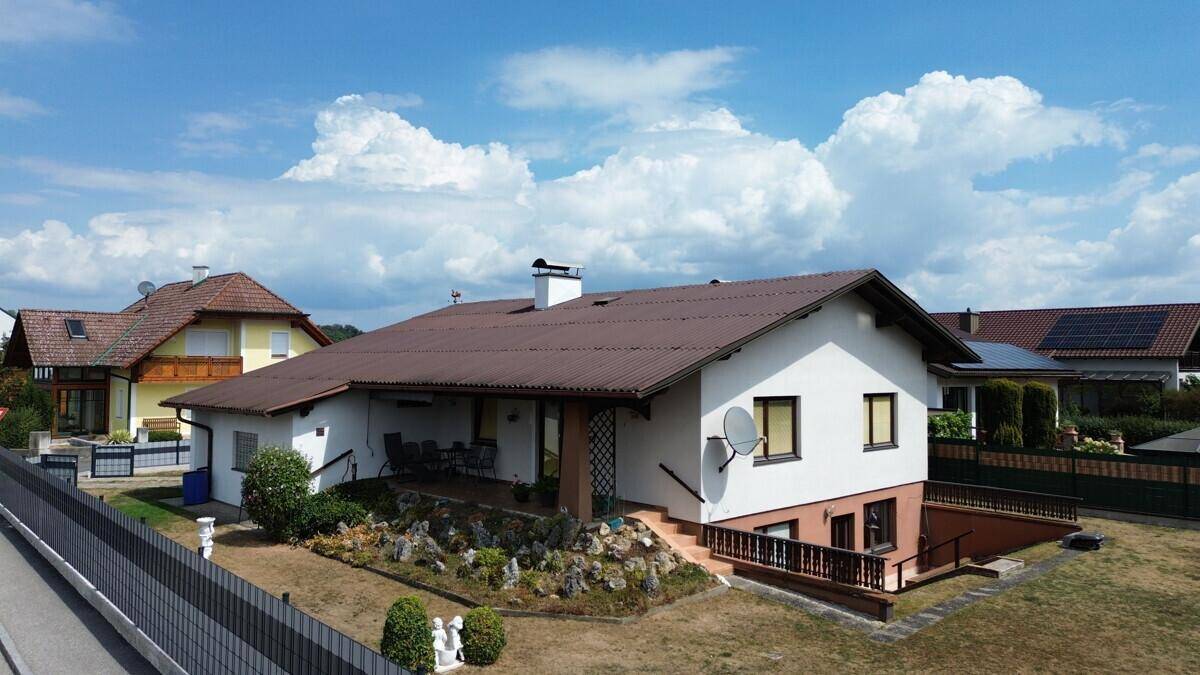 Überdachte Terrasse mit Sitzgelegenheiten und Blick auf den Gartenbereich des Hauses.