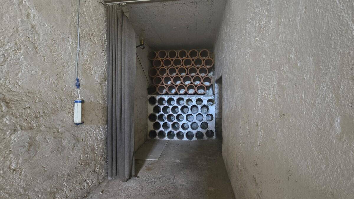 Kellerraum mit Tonröhren zur Lagerung von Flaschen und rauen Wänden, ideal als Weinkeller.