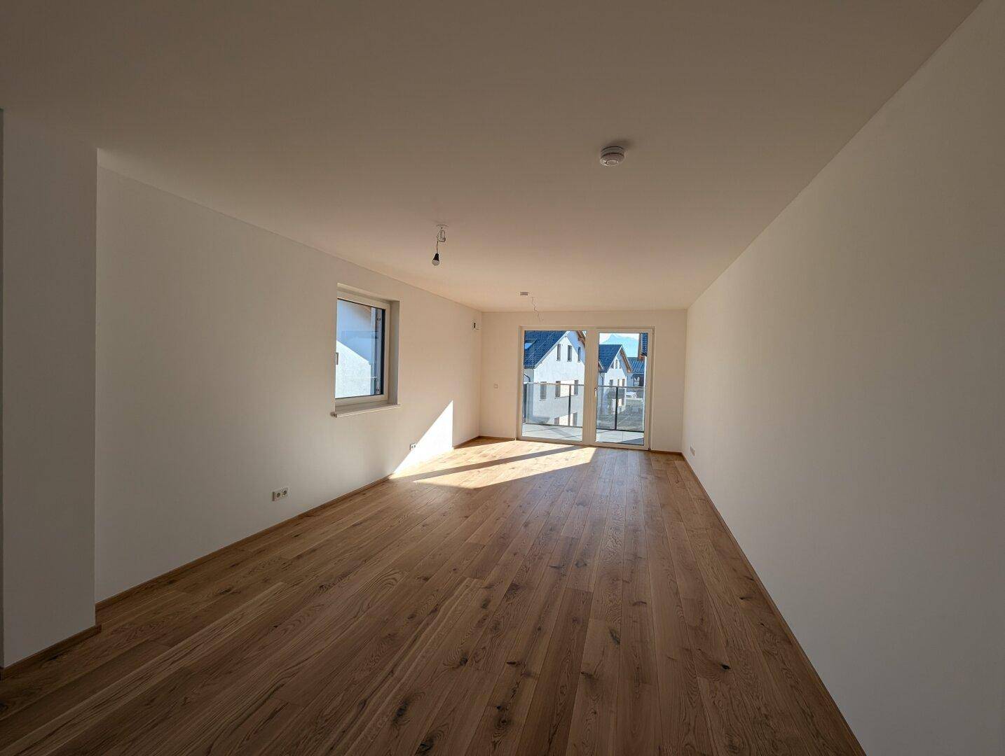 Geräumiges, helles Wohnzimmer mit Eichenparkett und Zugang zur Terrasse oder Garten.