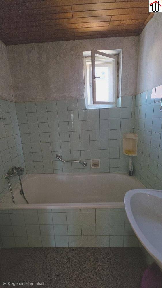 Badezimmer mit hellgrünen Fliesen, Badewanne, Waschbecken und kleinem Fenster, mit Holzdecke.