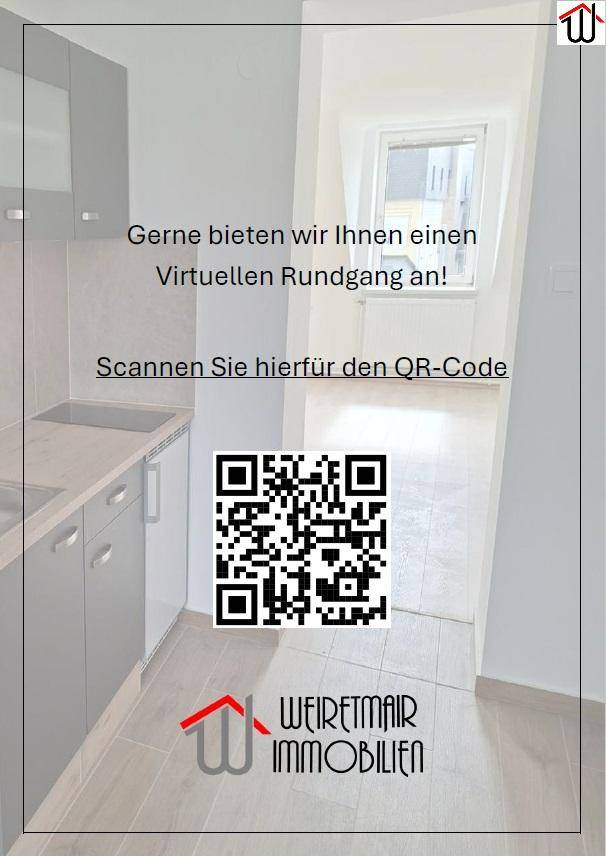 Kleine Küche mit grauen Schränken und Fliesenboden, angrenzend an einen hellen Raum mit Fenster.