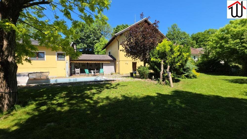 Großer grüner Garten mit Rasenfläche und Bäumen hinter dem Wohnhaus.