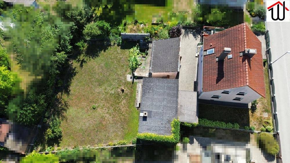 Luftaufnahme des Einfamilienhauses mit großem Garten und umliegender Bebauung.