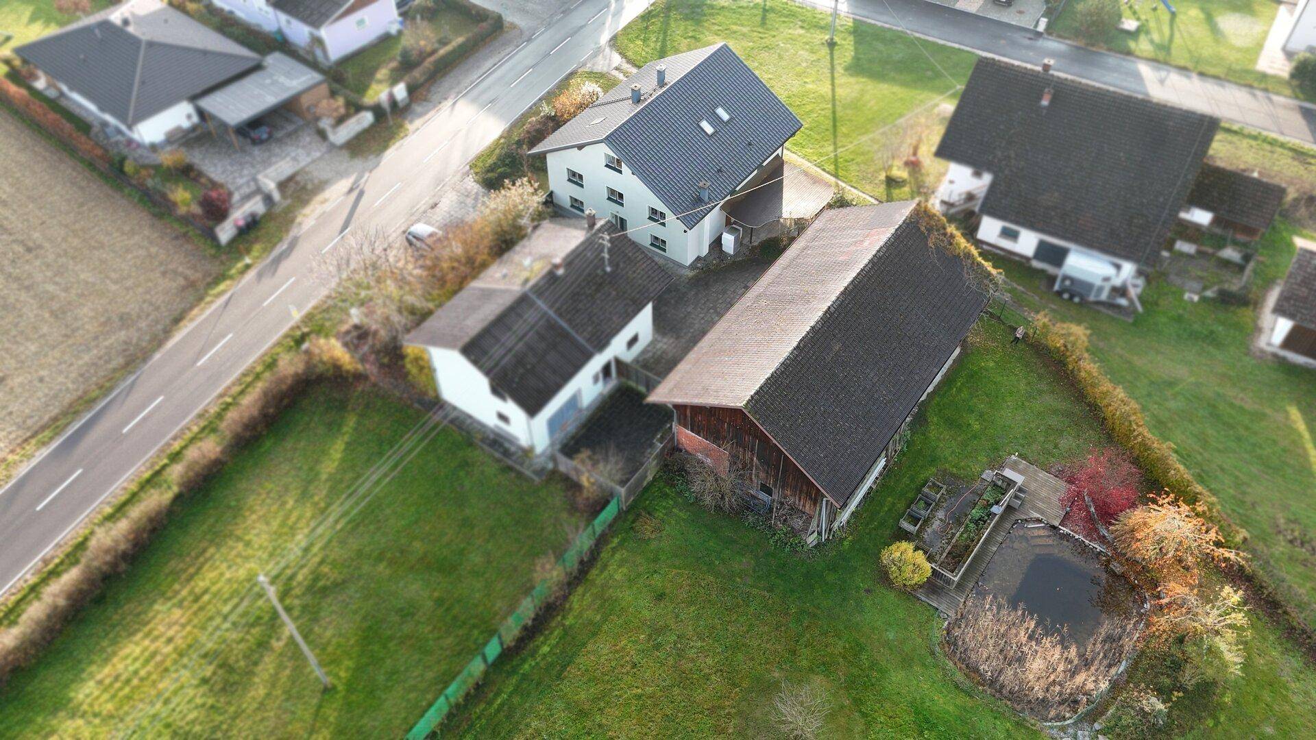 Luftaufnahme des Anwesens mit Wohnhaus, Scheune und großem Grundstück in ländlicher Umgebung.