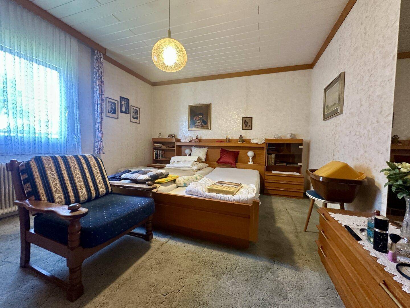 Geräumiges Schlafzimmer mit Doppelbett, Holzmöbeln und Teppichboden.
