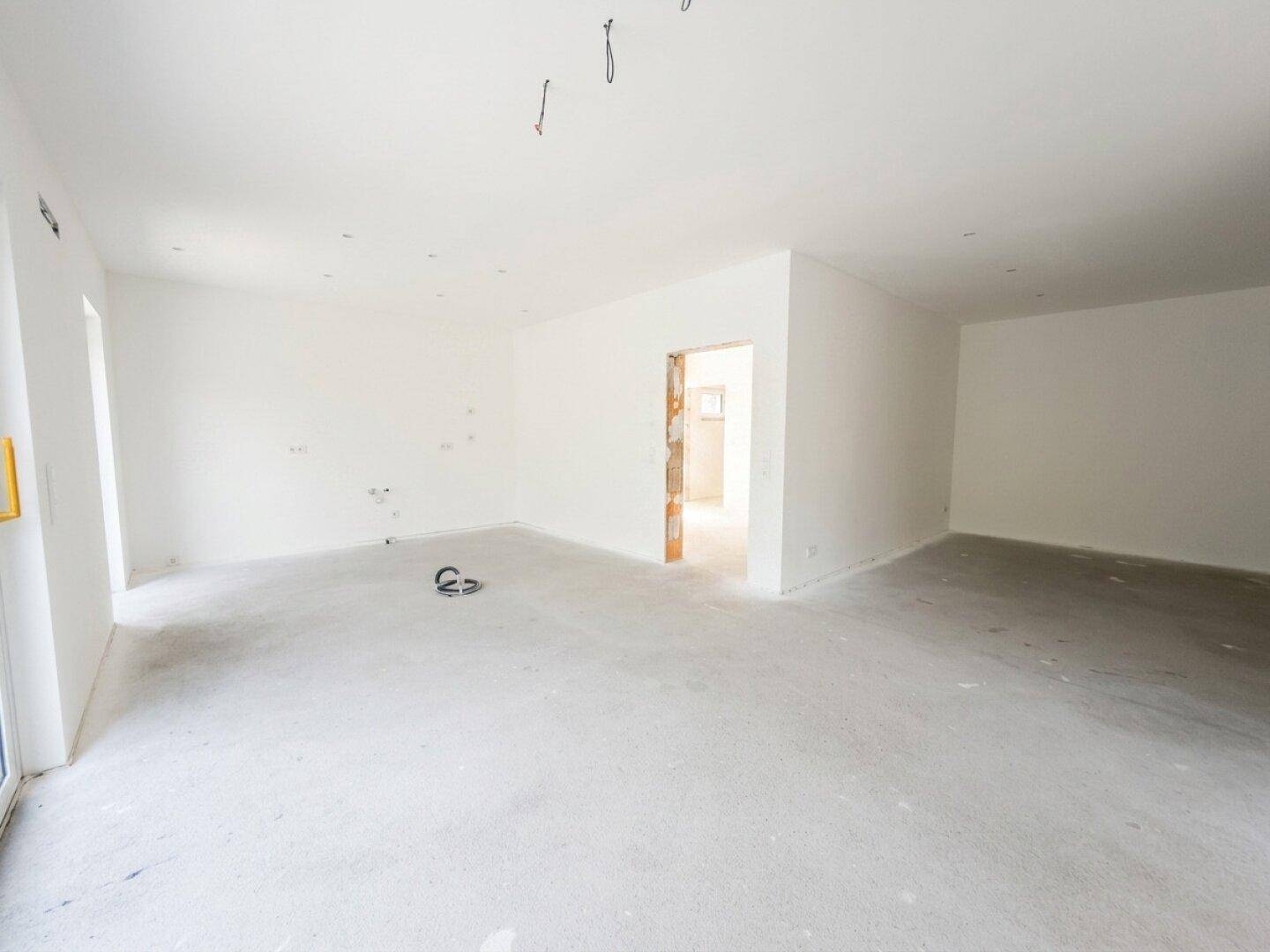 Heller, unfertiger Raum mit glatten Wänden und Decken, bereit für den finalen Ausbau.