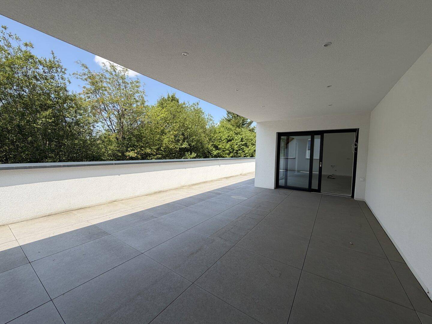 Geräumige, geflieste Terrasse mit weitem Blick ins Grüne und viel Platz zum Entspannen.