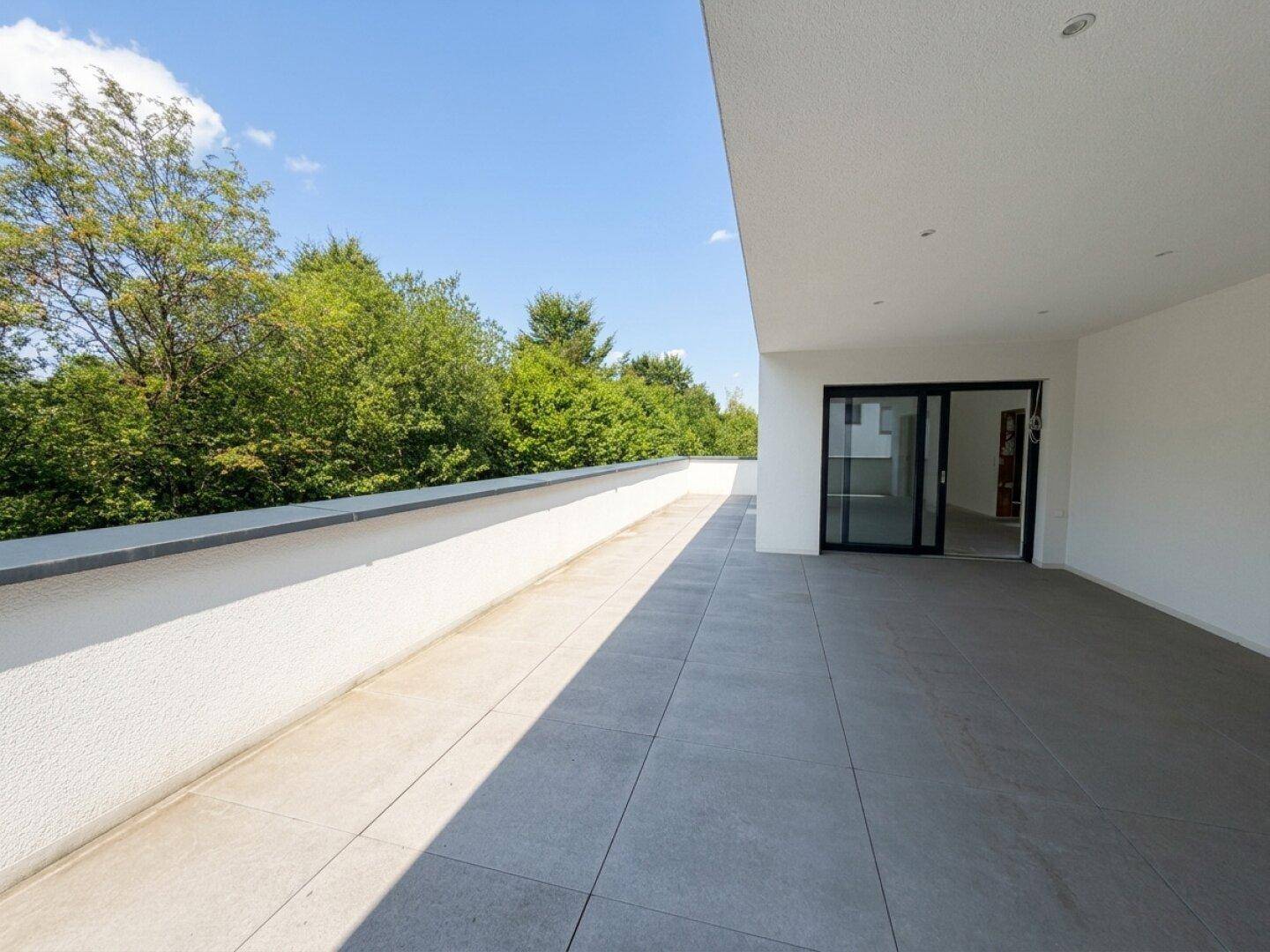 Geräumige, geflieste Terrasse mit viel Sonnenlicht und Zugang zu den Innenräumen.