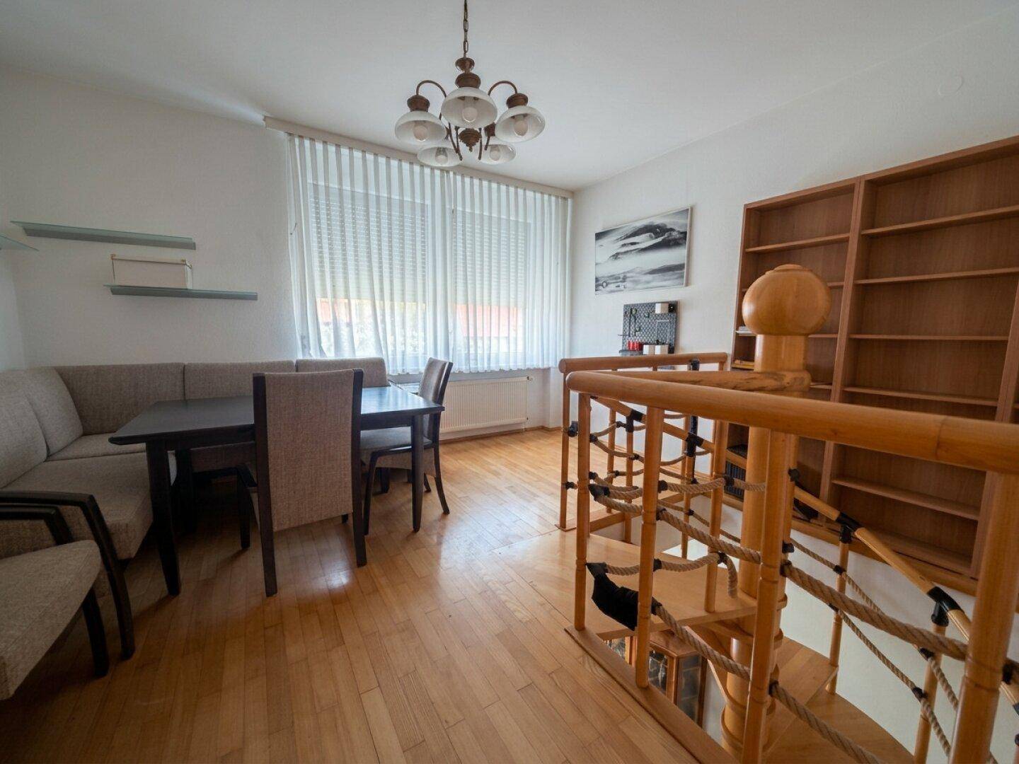 Essbereich mit Holztisch, Stühlen, Bücherregal und einer einzigartigen Holzspielstruktur.