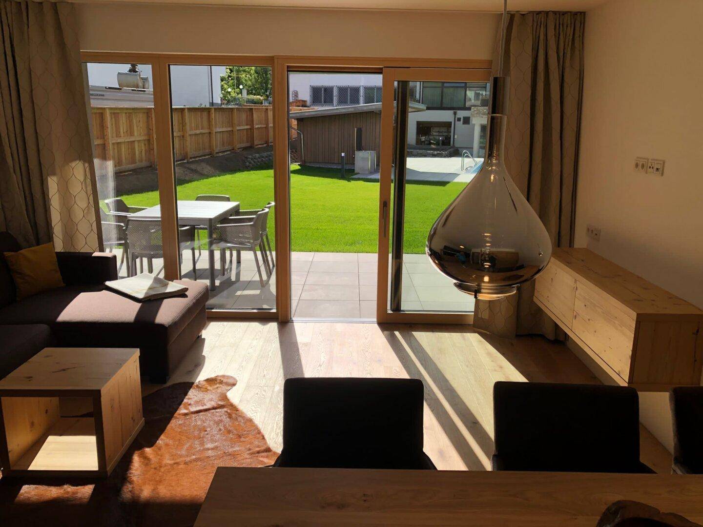Heller Wohn- und Essbereich mit Zugang zur Terrasse und privatem Garten mit kleinem Pool.