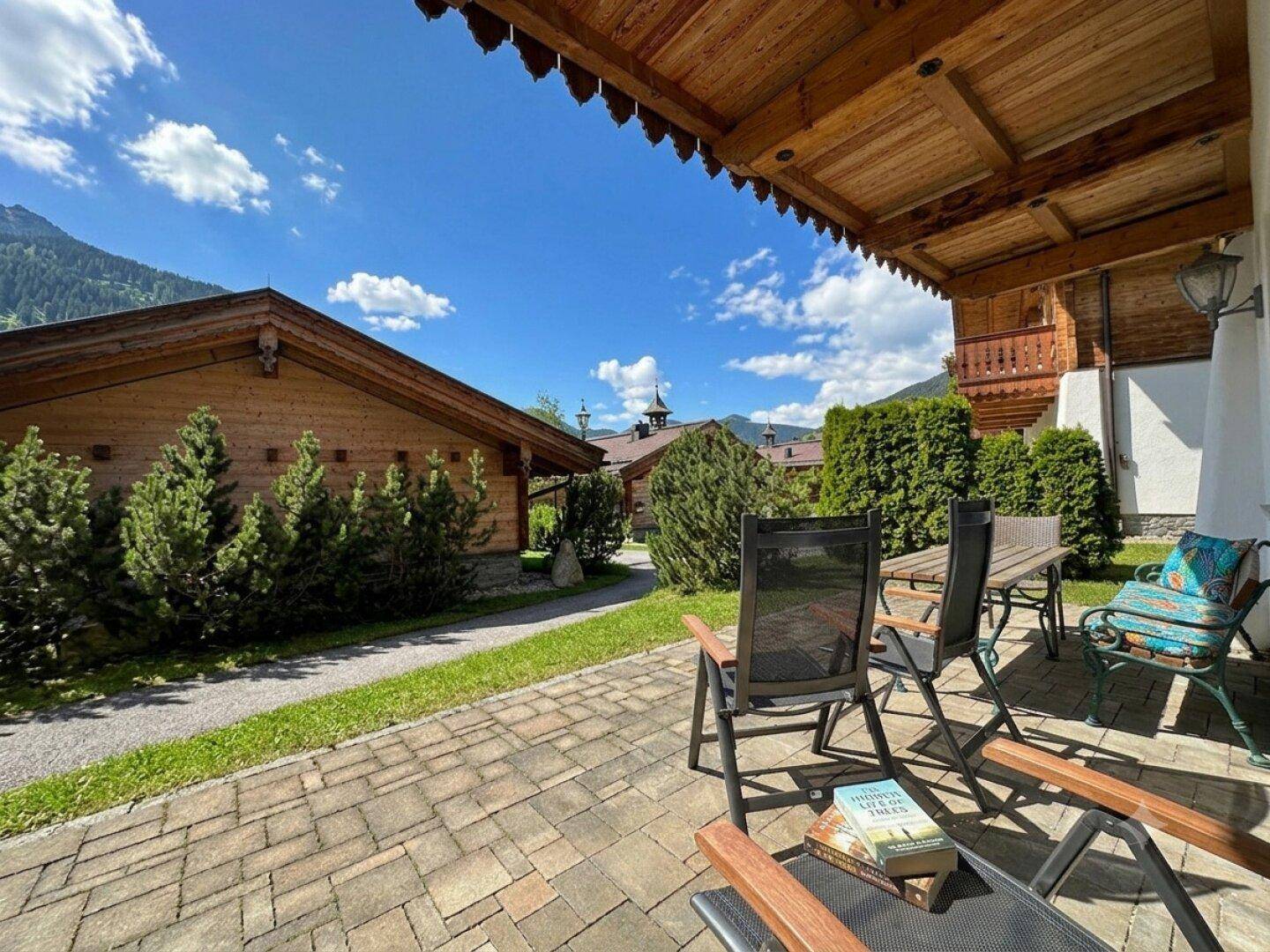 Gemütliche Terrasse mit Sitzgelegenheiten und Blick auf die umliegende Natur und weitere Chalets.