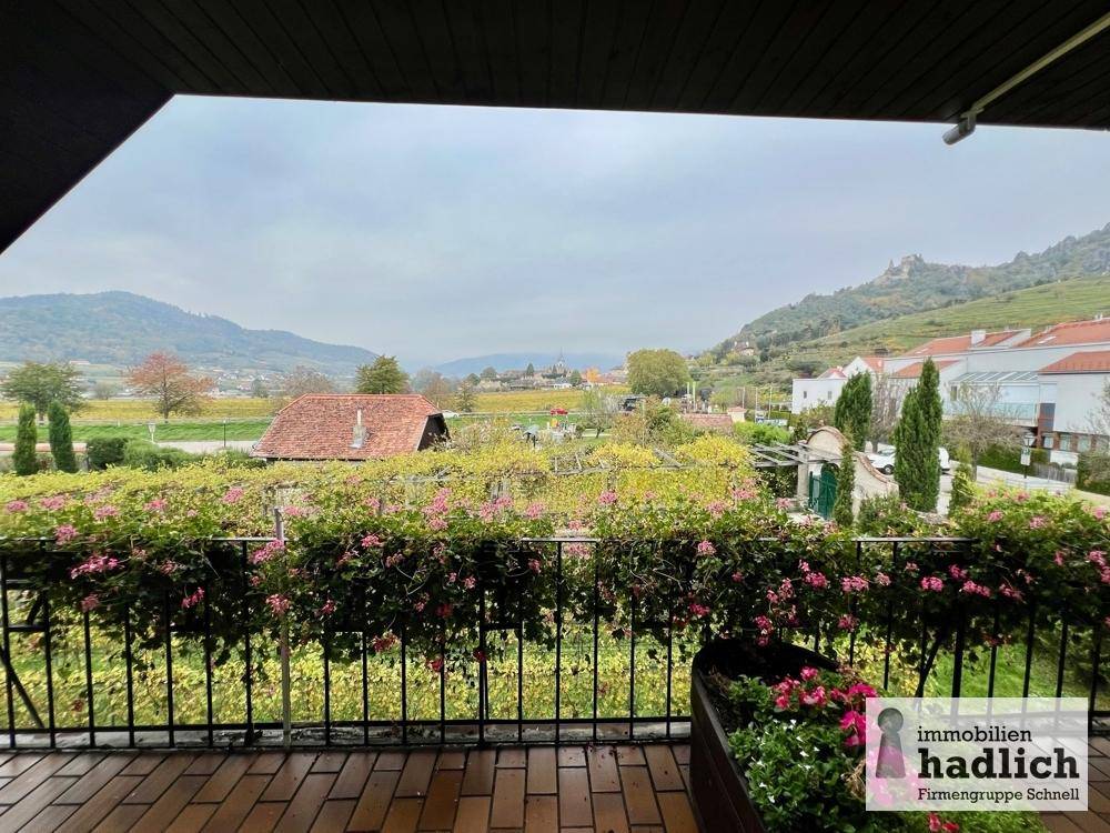Balkon mit Blumenkästen und weitem Blick auf die umliegende Landschaft und Weinberge.