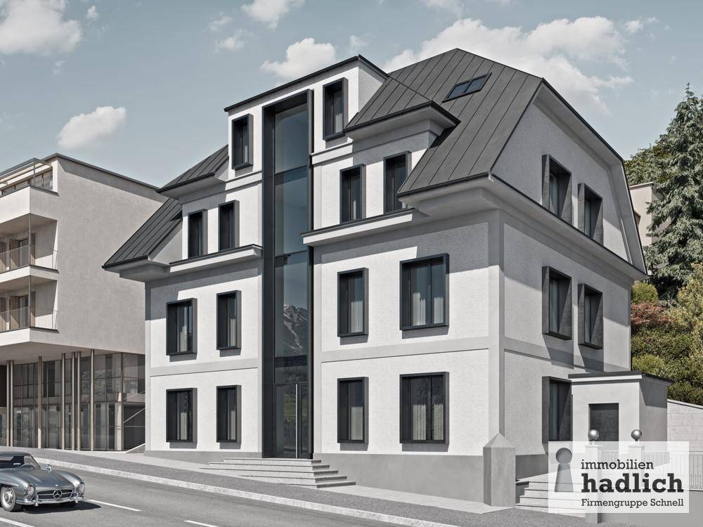 Elegantes Gebäude mit moderner Architektur, weißer Fassade und Mansarddach.