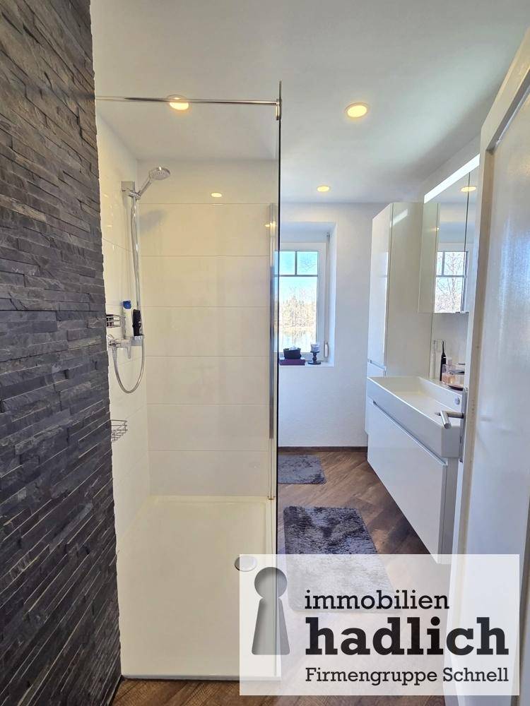 Modernes Badezimmer mit begehbarer Dusche, Doppelwaschbecken und Fenster.