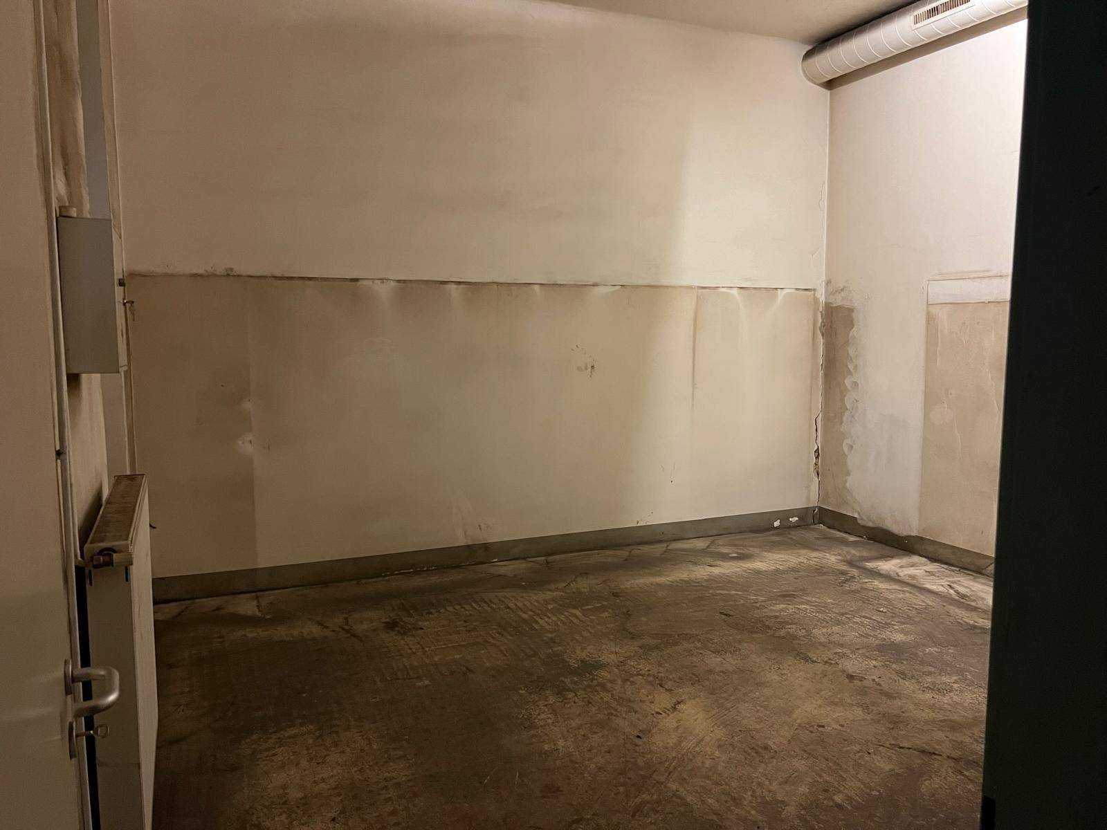 Kleiner, leerer Raum mit schmutzigen Wänden und Betonboden, der dringend renoviert werden muss.