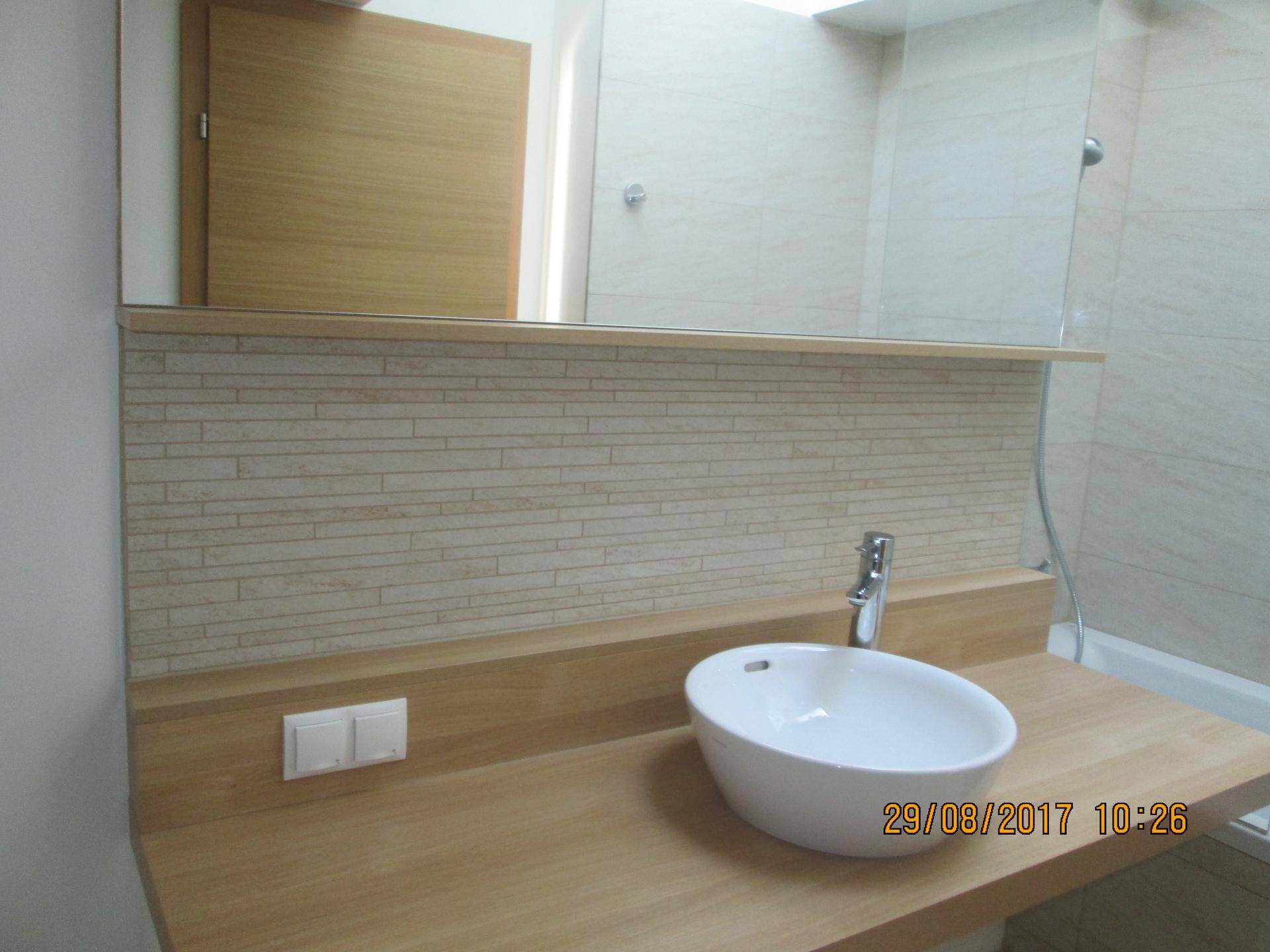Detailansicht des Waschbereichs im Badezimmer mit modernem Aufsatzwaschbecken und Holzplatte.