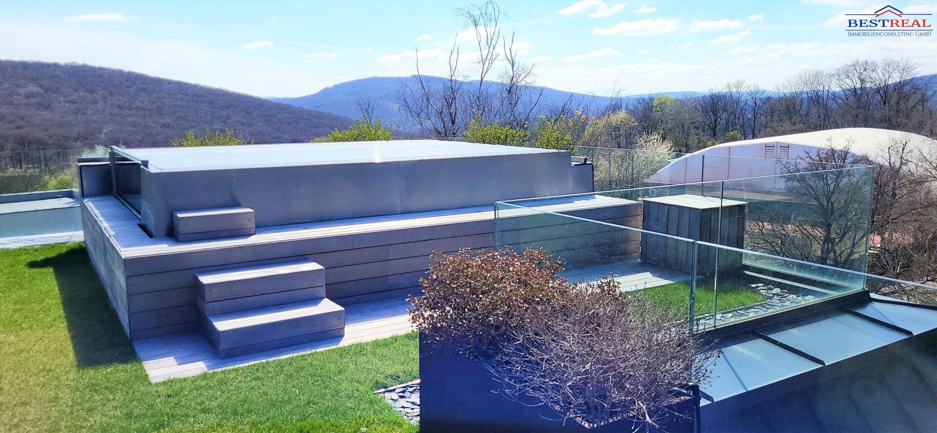Große Dachterrasse mit integriertem Whirlpool und weitem Blick über die umliegende Landschaft.