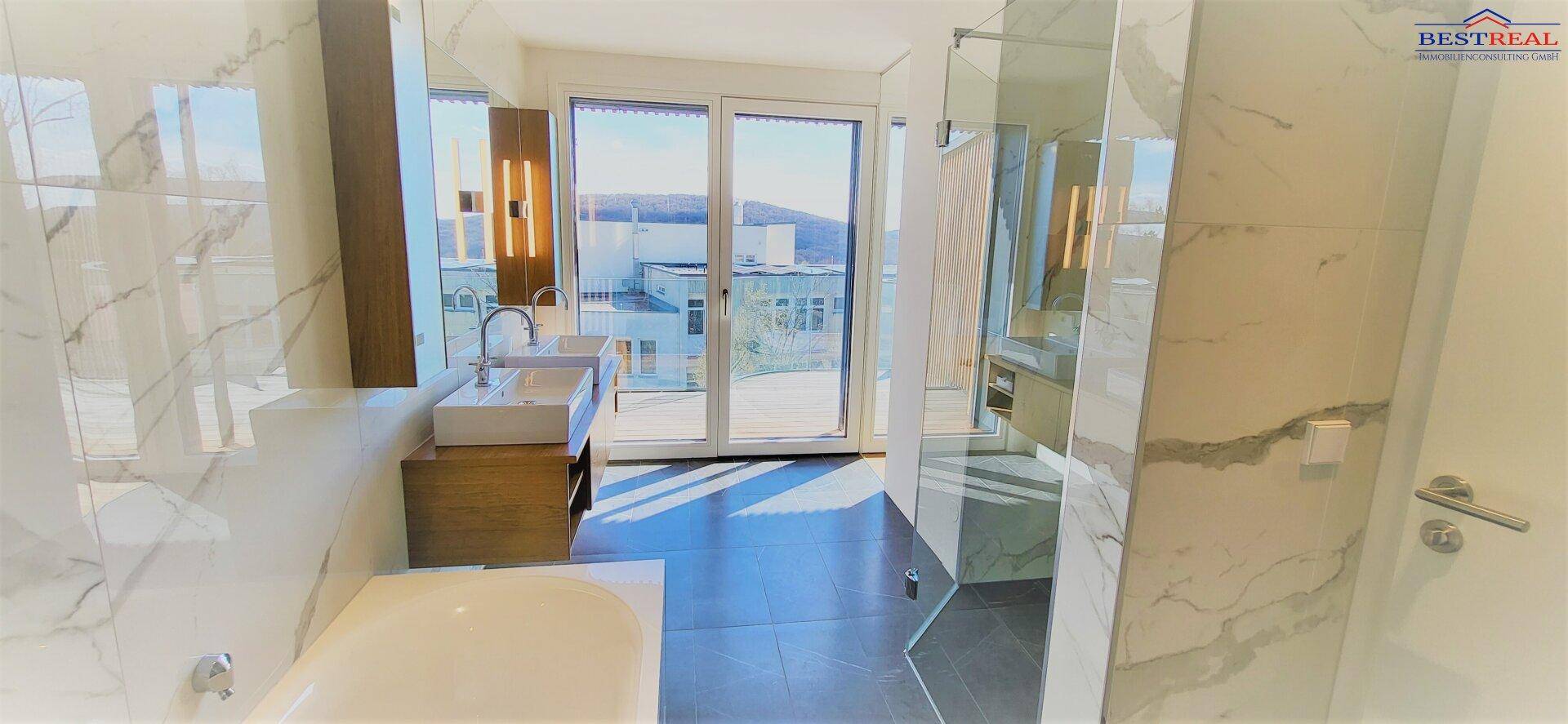Modernes Badezimmer mit Doppelwaschbecken, Badewanne und Dusche, hell gefliest und mit Fenster.