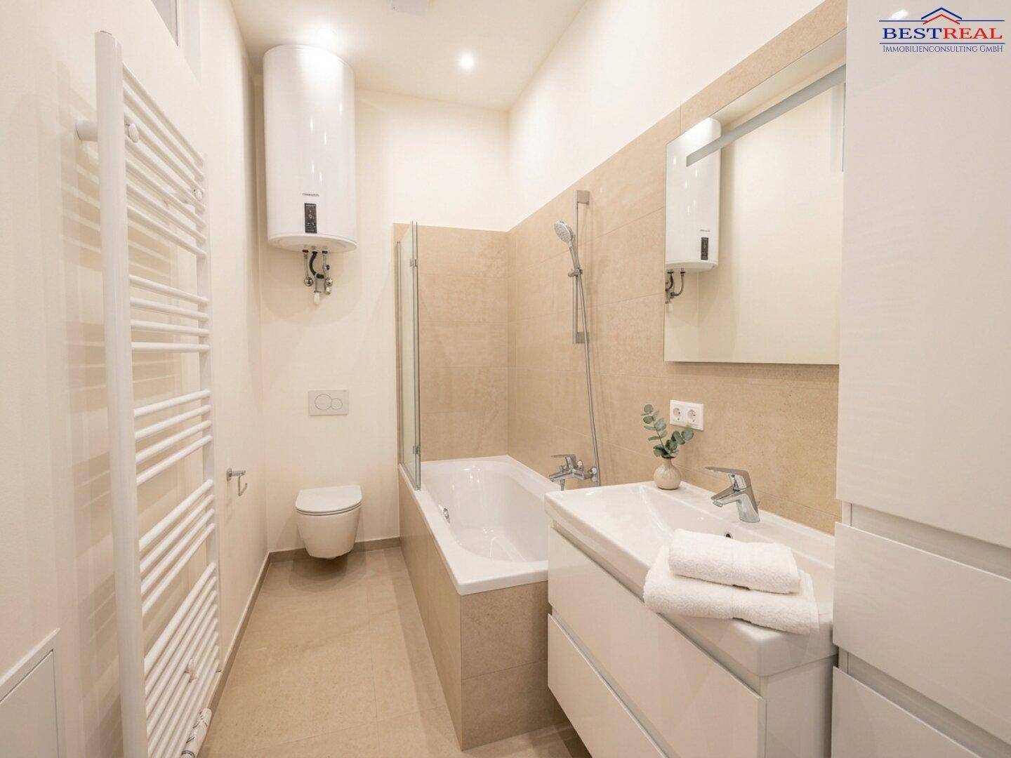 Helles Badezimmer mit Badewanne, Waschbecken und WC, ausgestattet mit modernen Armaturen.