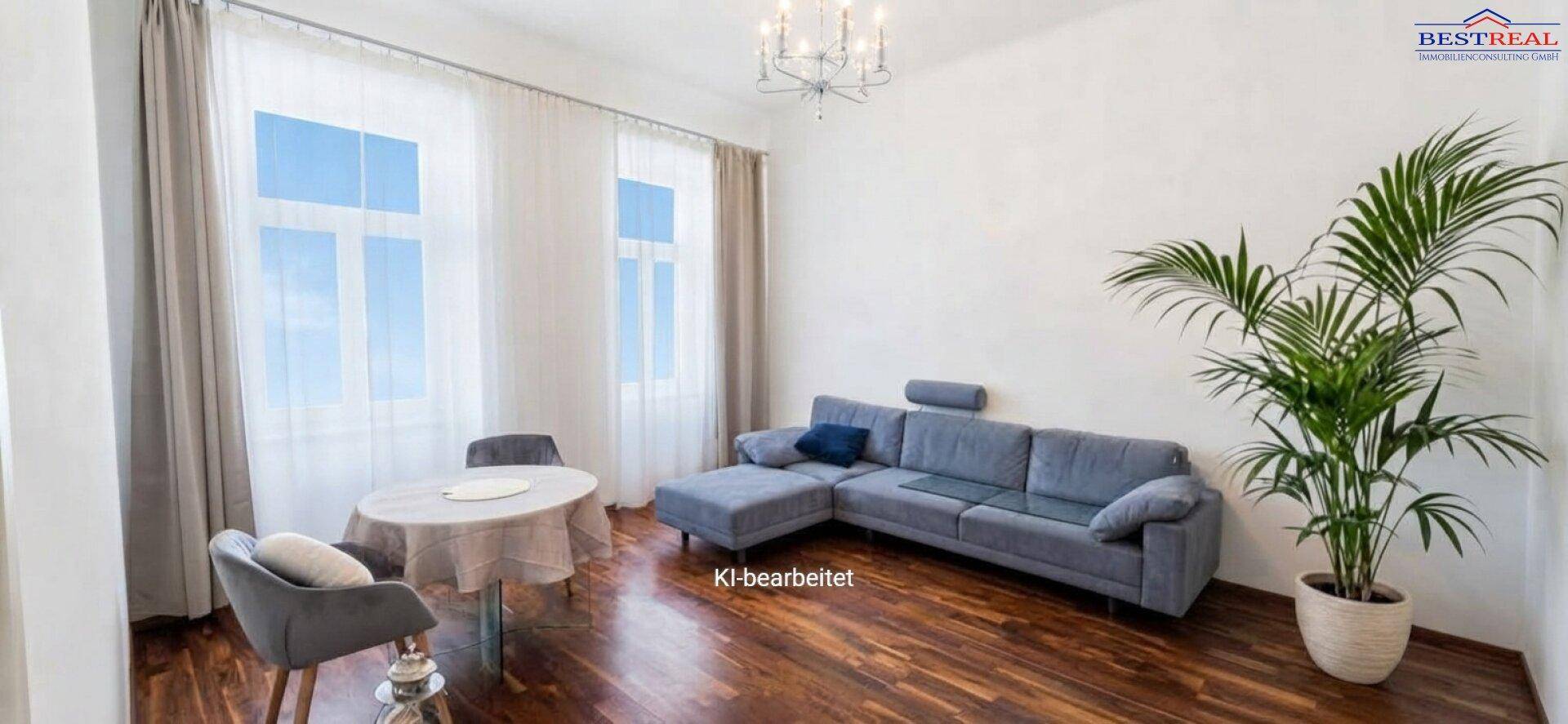 Helles Wohnzimmer mit modernem Sofa, kleinem Esstisch und großen Fenstern mit viel Tageslicht.