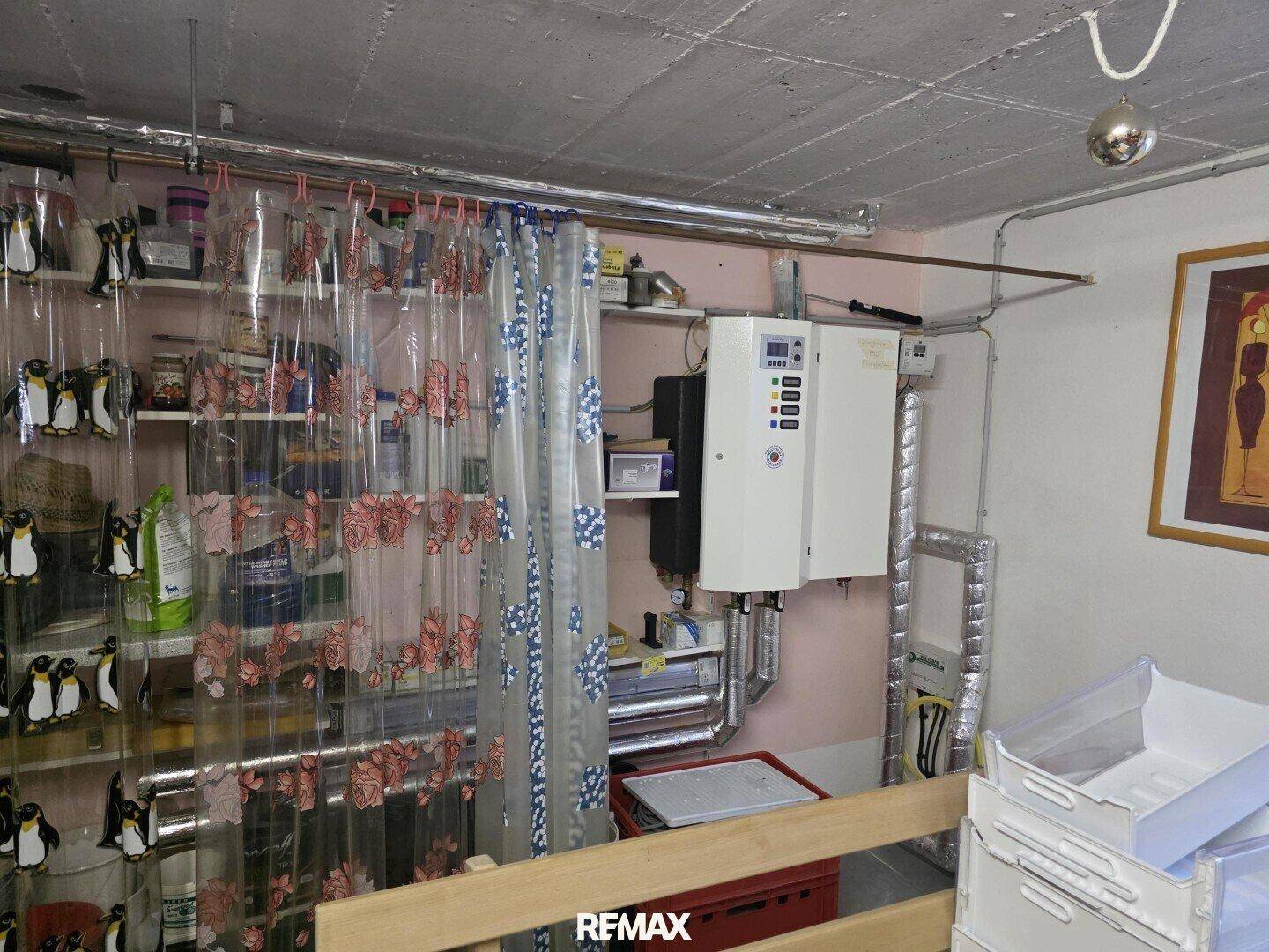 Funktionaler Hauswirtschaftsraum im Keller mit Heizungsanlage, Regalen und Stauraum.