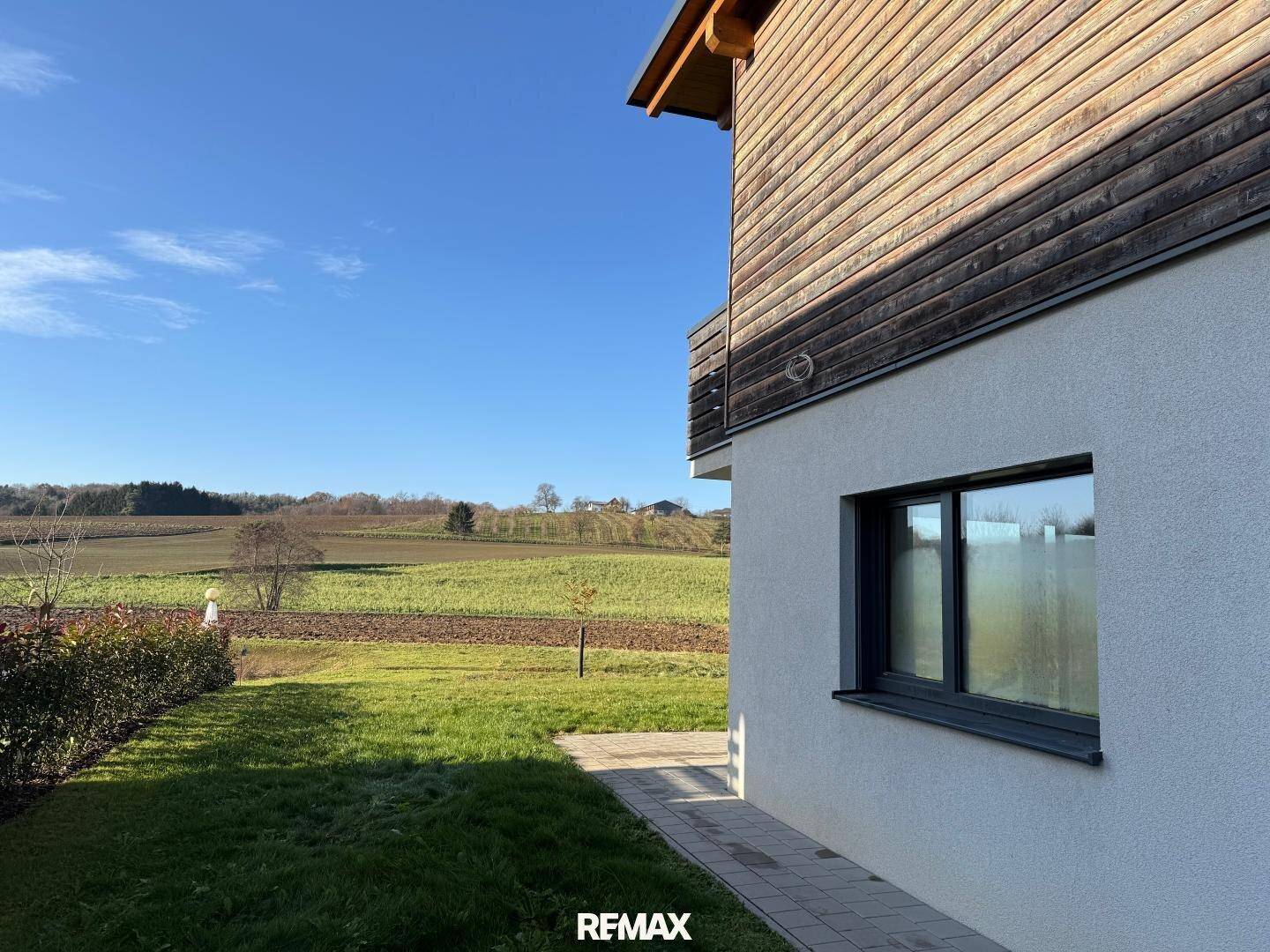Kleine Rasenfläche neben dem Haus mit Blick auf die weite, grüne Landschaft.