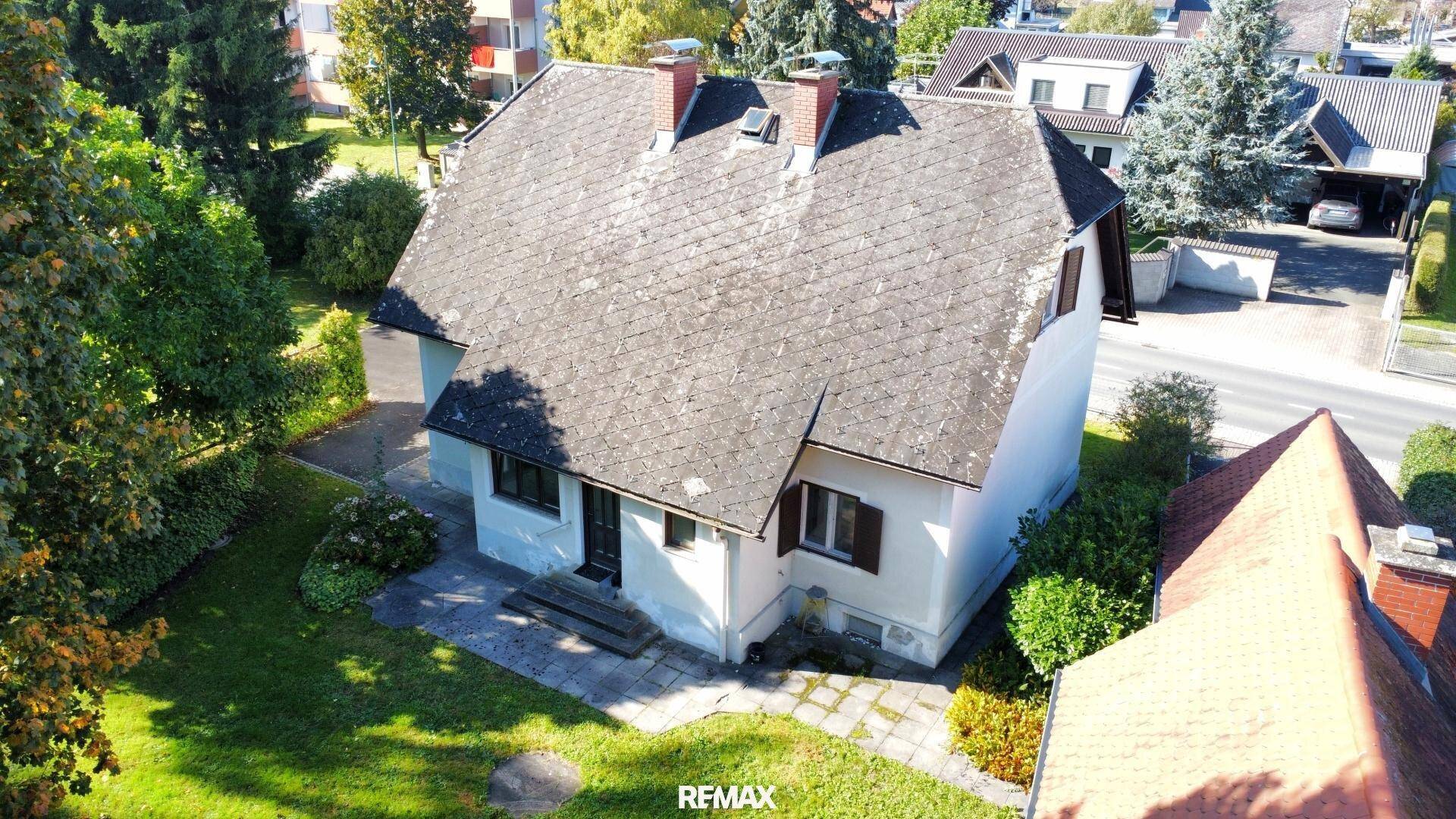 Luftaufnahme eines traditionellen Hauses mit Satteldach und umliegendem Grundstück.