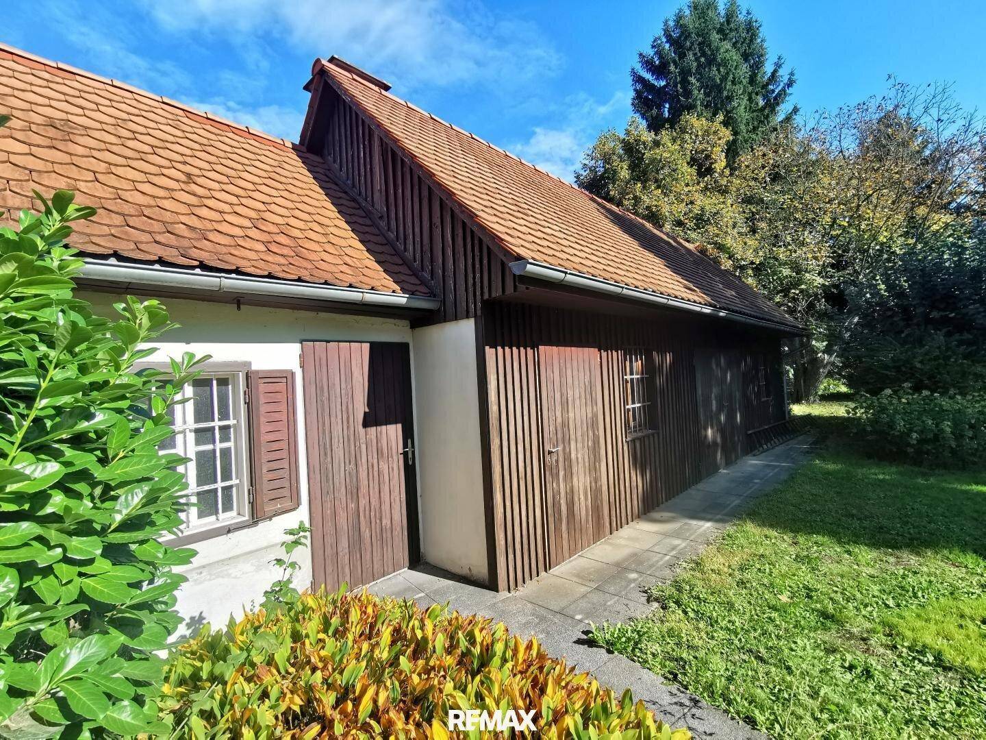 Rustikales Nebengebäude aus Holz mit Satteldach im Gartenbereich des Anwesens.