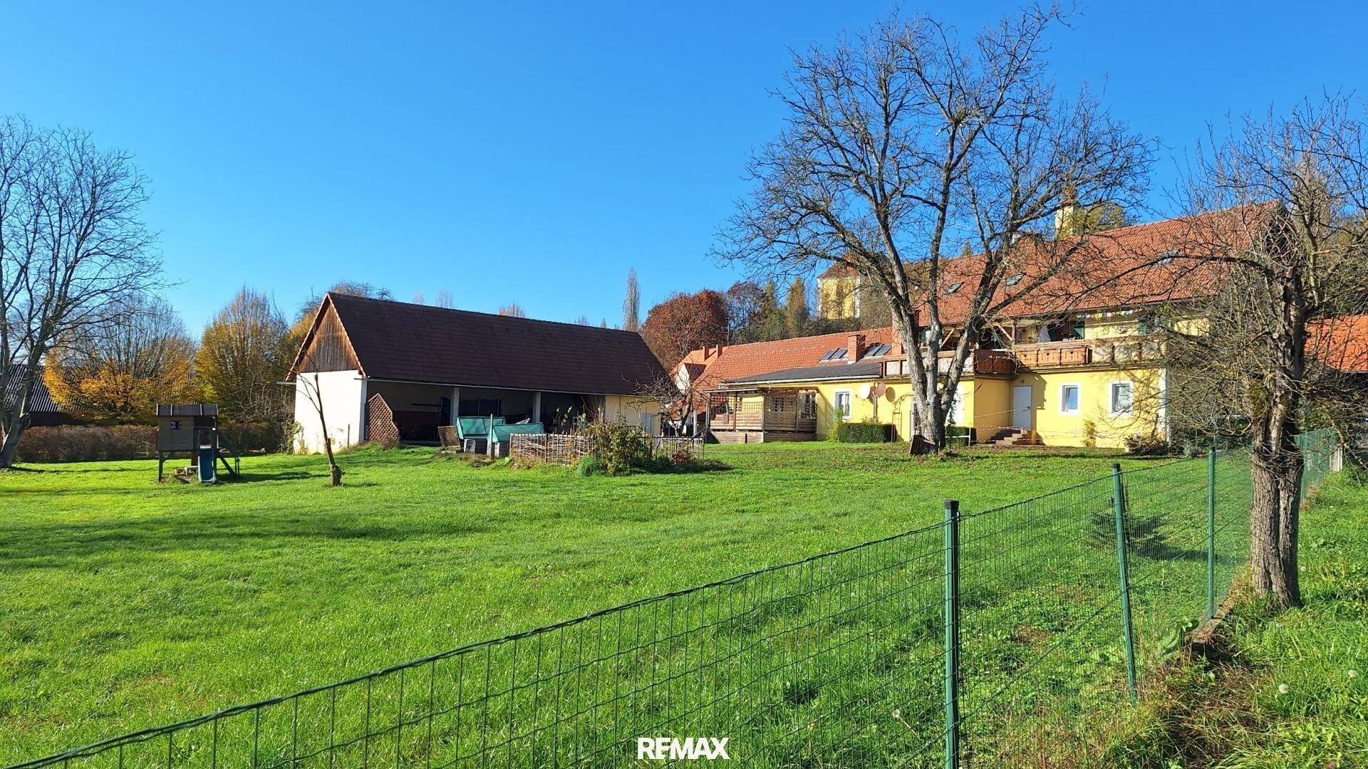 Großes Grundstück mit gelbem Haus, Scheune und weitem Blick in die ländliche Umgebung.